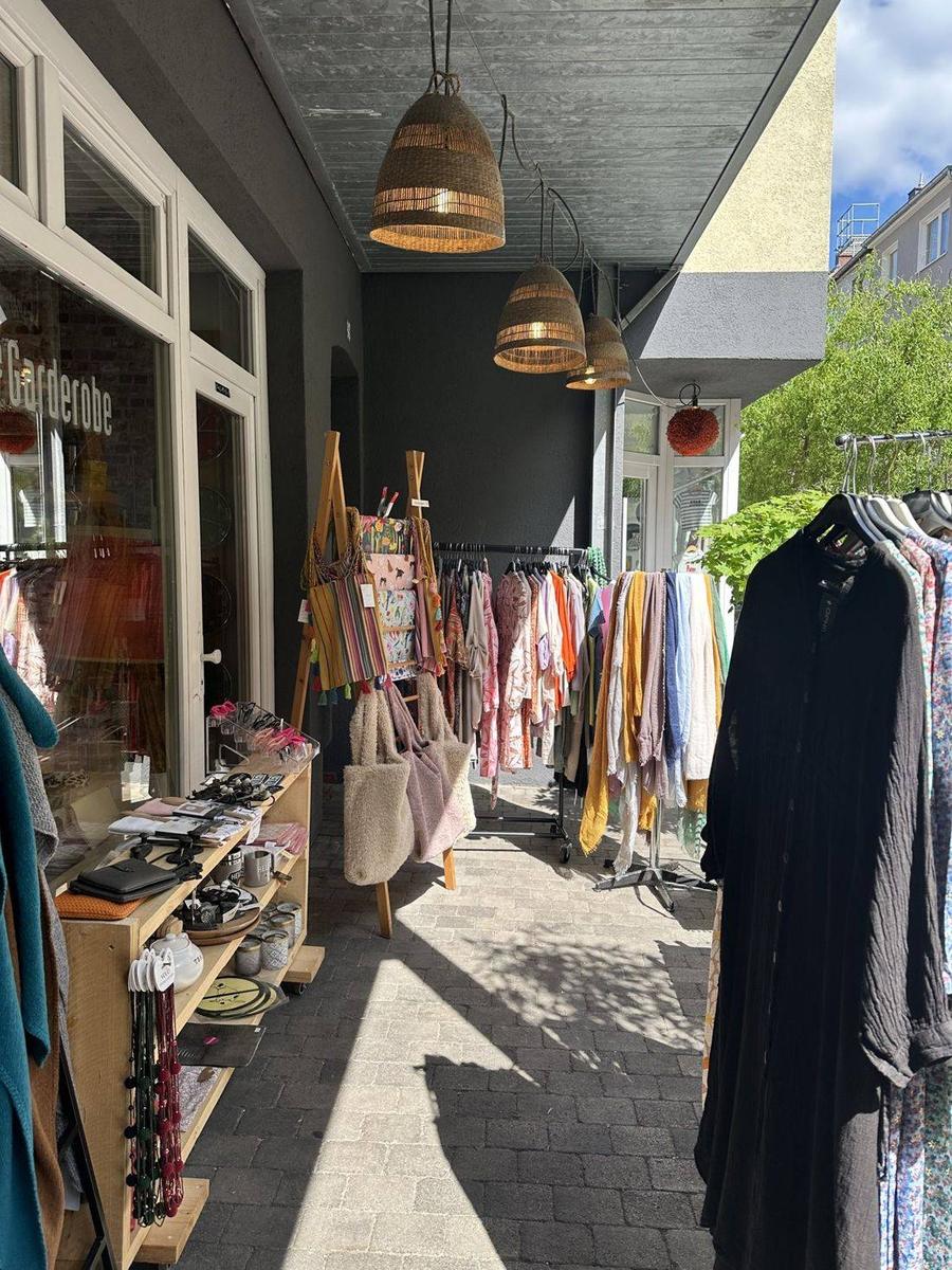 Eingangsbereich mit Kleiderständern und Korblampen im Sonnenlicht