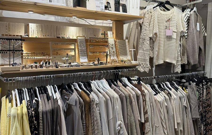 Schmuckdisplays mit Ketten und Ohrringen über einer Kleiderstange